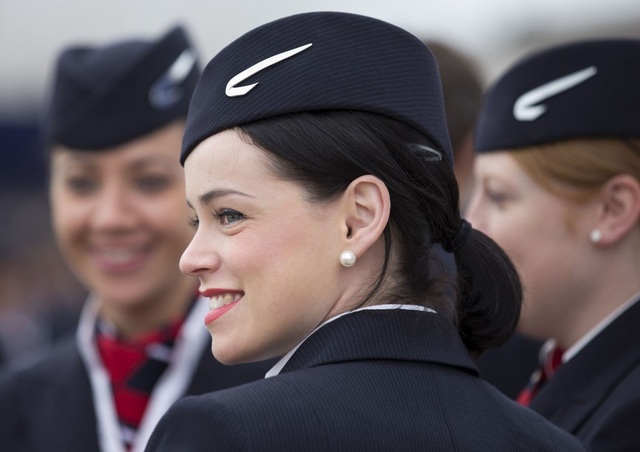 
Trong 2 năm đầu tiên, tiếp viên hàng chỉ là nghề dành cho nam giới. Tuy nhiên, tới năm 1930, các hãng hàng không Mỹ đã quyết định thuê những phụ nữ xinh đẹp và thân thiện để có thể thu hút nhiều hành khách sử dụng dịch vụ hơn. Trong ảnh: Tiếp viên hãng British Airways mỉm cười tại sự kiện hãng hàng không nước Anh nhận máy bay Airbus A380. (Ảnh: AFP)
