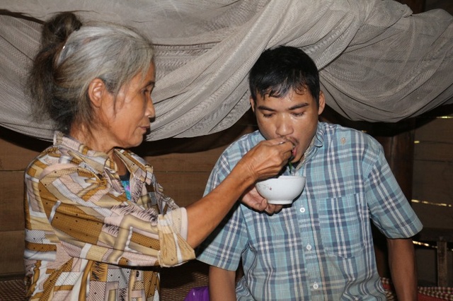 Khốn cùng cảnh cả gia đình sống nhờ tiền trợ cấp tàn tật của con - 1 Bà Hương đang bón cơm cho đứa con trai năm nay gần 40 tuổi