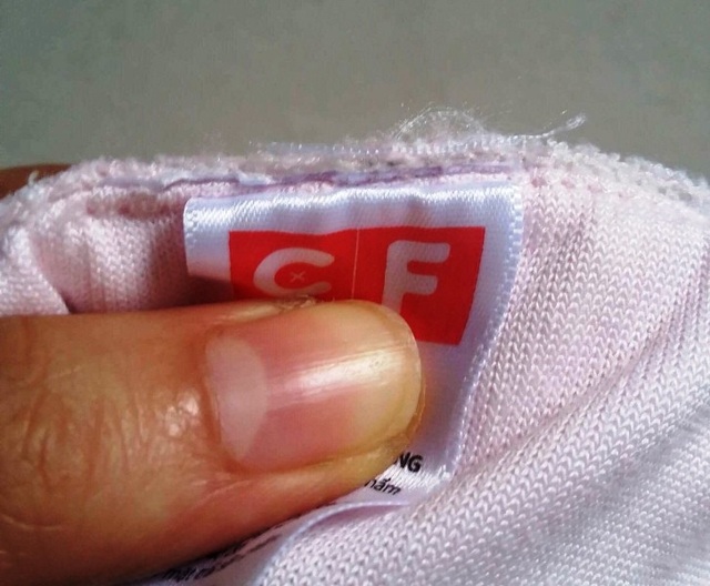 Chuỗi cửa hàng đồ trẻ em, bà bầu Con Cưng: Cắt tem nhãn, gắn... "mác ngoại"? - 2 Tem nhãn của bộ quần áo có dấu hiệu bị cắt và thay thế bằng tem nhãn khác.