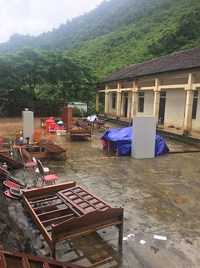 Nước lũ đe dọa cuốn trôi nhà ở của các giáo viên mầm non - 1 Các giáo viên ở trường đã vận chuyển đồ dùng dạy học, bàn ghế ra ngoài sân để tránh sạt lở phòng học có thể cuốn trôi.