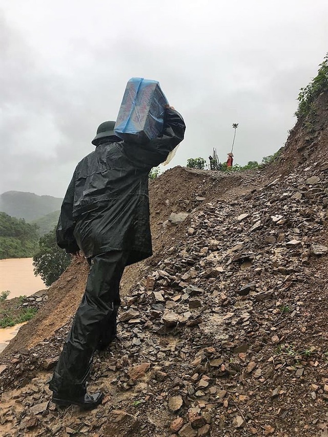 Nước lũ đe dọa cuốn trôi nhà ở của các giáo viên mầm non - 6 Cán bộ men theo vách núi sạt lở đưa lương thực đến cho các hộ dân.