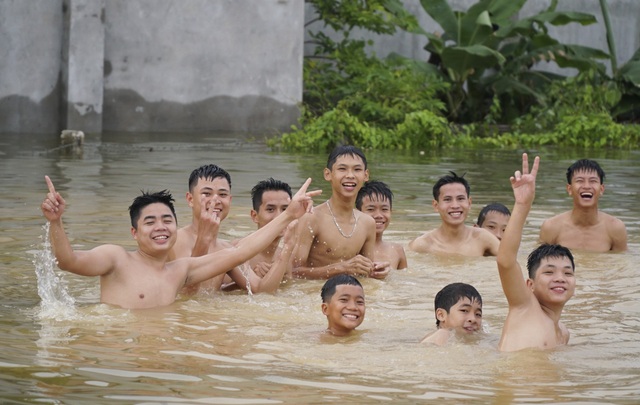 Hà Nội: Xã ngoại thành hễ mưa là ngập, dân chèo thuyền trên đường làng - 10
Cuộc sống đảo lộn, nhiều thanh niên trong làng được dịp bơi lội thỏa thích