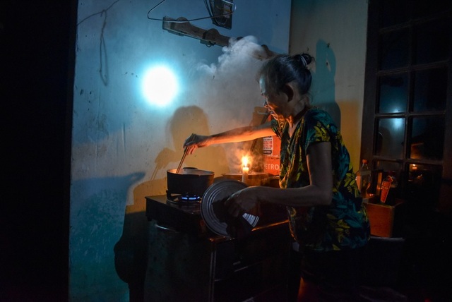 Người dân Hà Nội ăn ngủ trên thuyền, sống chung với lũ - 11 May mắn hơn, gia đình bà Hoàng Thị Duyên kê cao bếp và có thể nấu cơm, nhưng chưa có điện nên bà Duyên vẫn phải dùng nến và đèn pin để chiếu sáng.