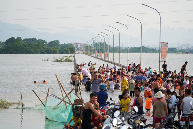 Hà Nội: Trẻ em thỏa thích bơi lội trên... tỉnh lộ - 1
Chiều 22/7, tuyến đường huyết mạch chạy qua địa phận huyện Quốc Oai (từ Đại lộ Thăng Long nối Xuân Mai) ngập sâu kéo dài hàng trăm mét khiến các phương tiện giao thông không thể đi qua.