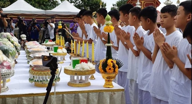 Đội bóng nhí Thái Lan bắt đầu nghi lễ đi tu sau khi được giải cứu - 3
11 cầu thủ và huấn luyện viên Ekapol 25 tuổi mặc trang phục trắng, cùng nhau thắp lên những ngọn nến vàng, chắp tay cúi lạy trước tượng Phật trong buổi lễ trang trọng này. (Ảnh: Reuters)