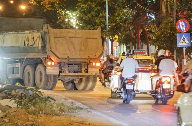 Hà Nội: Xe tải "vượt" biển cấm, dân khốn khổ vì bão bụi - 3
Năm 2013, UBND thành phố Hà Nội đã có Quyết định 06/2013/QĐ-UBND về hoạt động của các phương tiện giao thông trên địa bàn. Theo đó, các loại ô-tô vận tải có trọng lượng từ 1,25 tấn trở lên, xe vận chuyển hàng siêu trường, siêu trọng, xe chuyên dùng chỉ được phép lưu hành từ 21 giờ đến 6 giờ sáng ngày hôm sau và phải có giấy phép lưu hành của cơ quan có thẩm quyền. Chị Phan Thanh Bình – chủ một quán cà phê tại tuyến đường này chia sẻ: “Cứ tầm hơn 20h mỗi tối là những chiếc xe quá khổ ùn ùn kéo nhau đỗ dọc đường Hào Nam để chờ vào trong công trình. Nhiều hôm, đoàn xe tải khổng lồ này gây ách tắc kéo dài cả trăm mét, khói bị bay mù mịt cả đoạn đường”.