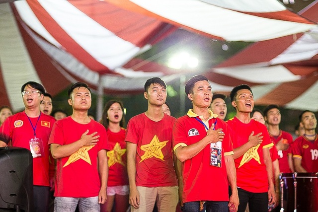 Người hâm mộ Việt Nam ăn mừng chiến thắng trước Bahrain - 2 Cổ động viên làm nghi thức chào cờ cùng đội tuyển U23 Việt Nam.