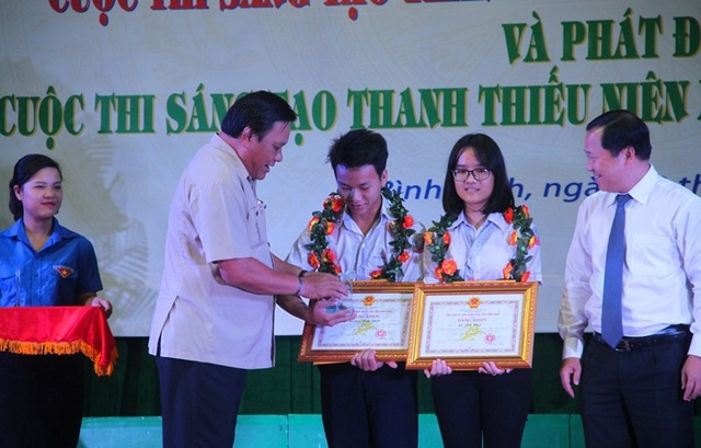 Học sinh sáng tạo “máy bóc vỏ dừa” thay sức người - 1 Phó Bí thư Thường trực Tỉnh ủy Bình Định Lê Kim Toàn (trái) và Phó Chủ tịch UBND tỉnh Bình Định Nguyễn Phi Long trao Bằng khen và Kỷ niệm chương cho nhóm tác giả đạt giải Nhất cuộc thi.