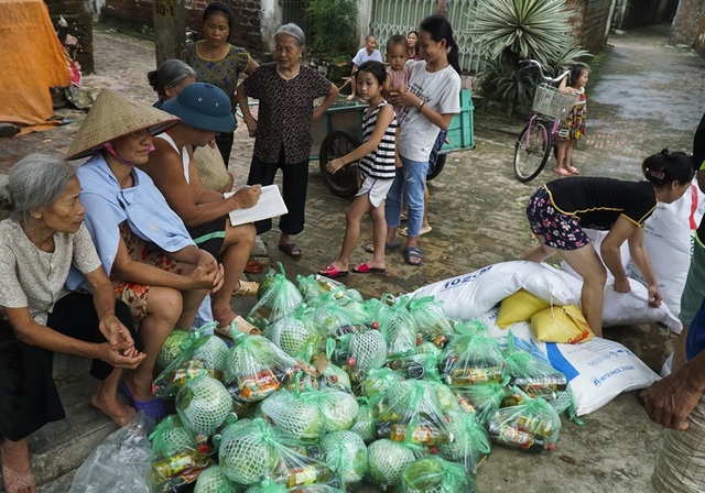 Hà Nội: Người dân vùng ngập chèo thuyền nhận quà từ thiện - 10
Các phần quà từ thiện đến tận tay người dân vùng lụt.