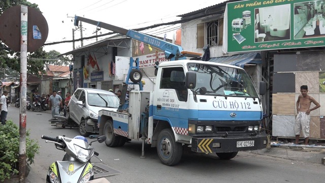 Lùi như bay, ô tô cuốn 3 xe máy vào gầm - 4 Cảnh sát điều xe cẩu di chuyển ô tô rời khỏi hiện trường