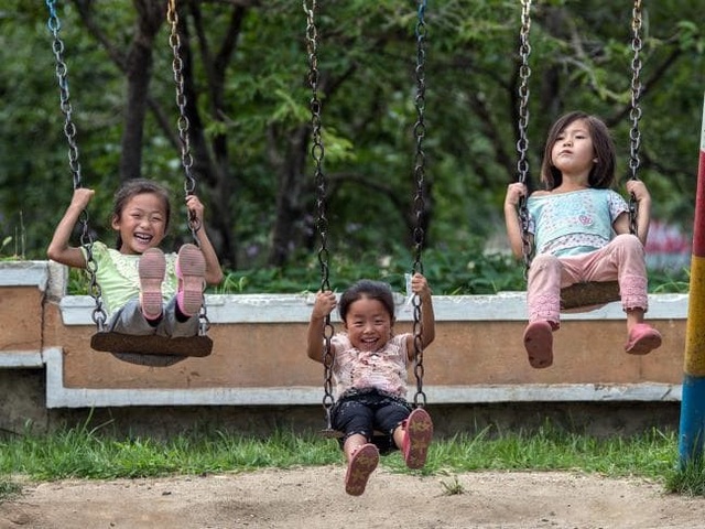 Khoảnh khắc vui chơi trong cuộc sống thường nhật của người Triều Tiên - 11 Nụ cười hồn nhiên của 3 em bé người Triều Tiên đang chơi xích đu ở Wonsan.