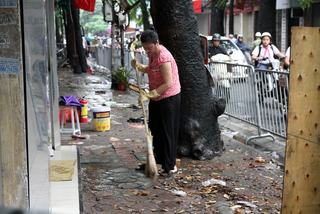 Toàn cảnh dãy nhà cháy rụi bên đường Đê La Thành nhìn từ trên cao - 9
Người dân quét dọn sau đám cháy.