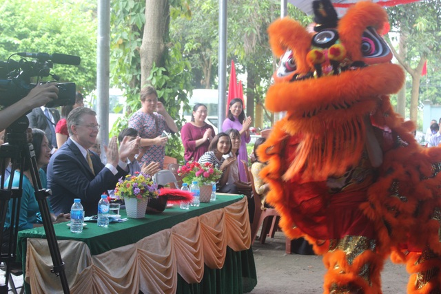 Đại sứ Mỹ múa lân, nặn bánh trung thu cùng trẻ em khuyết tật Việt Nam - 8 Đại sứ Kritenbrin hứng khởi khi được theo dõi màn múa lân đặc sắc. Nhà ngoại giao Mỹ đã đeo mặt nạ, cầm quạt và “hóa thân” thành Ông Địa hòa mình vào màn múa lân.