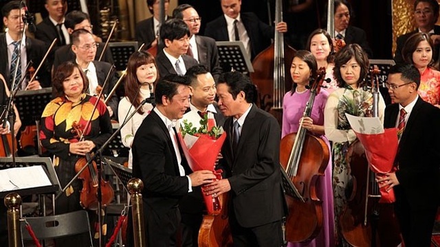 Thứ trưởng Hoàng Vĩnh Bảo tặng hoa chúc mừng nhạc trưởng Lê Phi Phi sau chương trình.