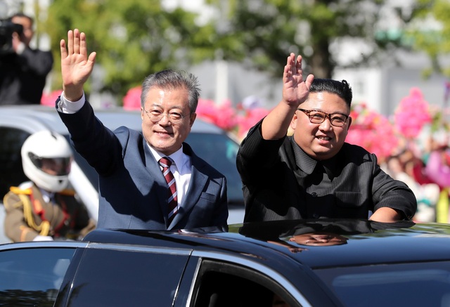 Tổng thống Moon Jae-in và nhà lãnh đạo Kim Jong-un đứng trên xe mui trần vẫy tay chào người dân Bình Nhưỡng. (Ảnh: Reuters)