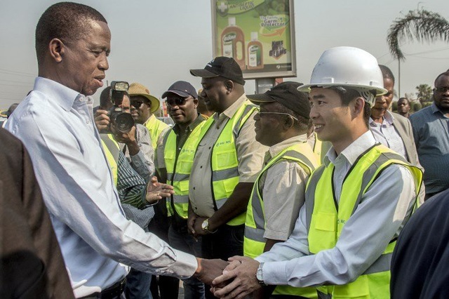 Tổng thống Zambia Edgar Lungu (bên trái) bắt tay một công nhân Trung Quốc (Ảnh: AFP)