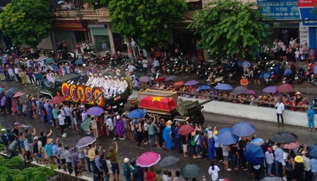 Người dân đội mưa đứng kín đường. (Ảnh: Nguyệt Ánh)