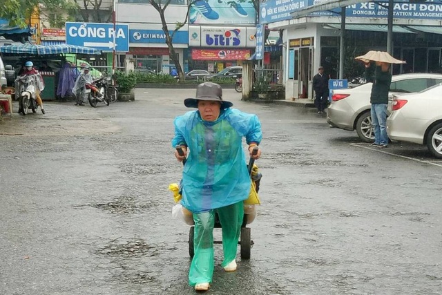Nhịp sống người lao động dưới những cơn mưa xứ Huế - 2
Một nữ lao công oằn vai kéo xe hàng giữa mưa