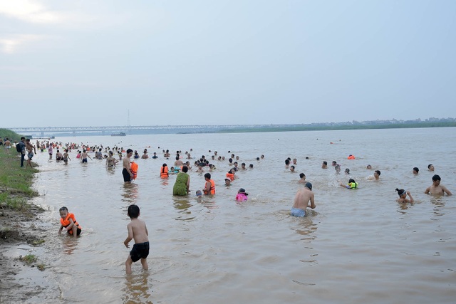 Bất chấp biển cấm, hàng trăm người đổ ra bãi cát ven sông Hồng tắm giải nhiệt - 13 Bất chấp biển cấm, hàng trăm người đổ ra bãi cát ven sông Hồng tắm giải nhiệt - 13