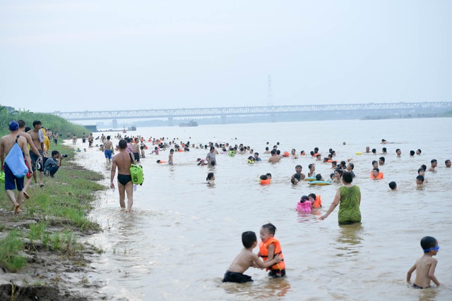 Bất chấp biển cấm, hàng trăm người đổ ra bãi cát ven sông Hồng tắm giải nhiệt - 8 Bất chấp biển cấm, hàng trăm người đổ ra bãi cát ven sông Hồng tắm giải nhiệt - 8