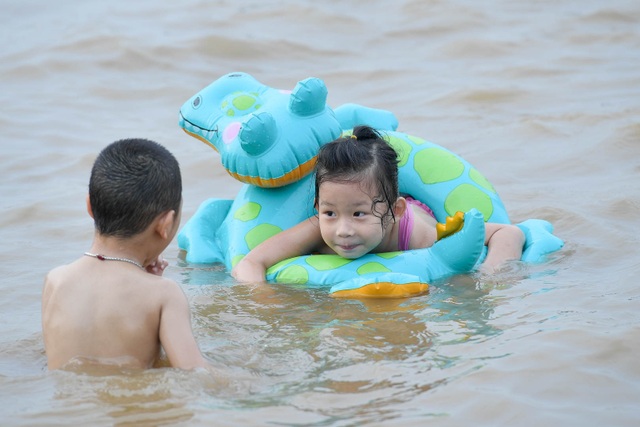 Bất chấp biển cấm, hàng trăm người đổ ra bãi cát ven sông Hồng tắm giải nhiệt - 9 Bất chấp biển cấm, hàng trăm người đổ ra bãi cát ven sông Hồng tắm giải nhiệt - 9