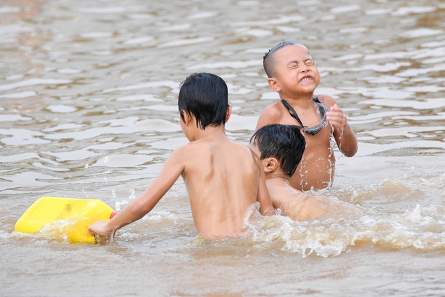 Bất chấp biển cấm, hàng trăm người đổ ra bãi cát ven sông Hồng tắm giải nhiệt  - 4