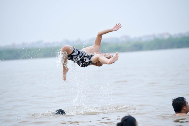 Bất chấp biển cấm, hàng trăm người đổ ra bãi cát ven sông Hồng tắm giải nhiệt - 11 Bất chấp biển cấm, hàng trăm người đổ ra bãi cát ven sông Hồng tắm giải nhiệt - 11