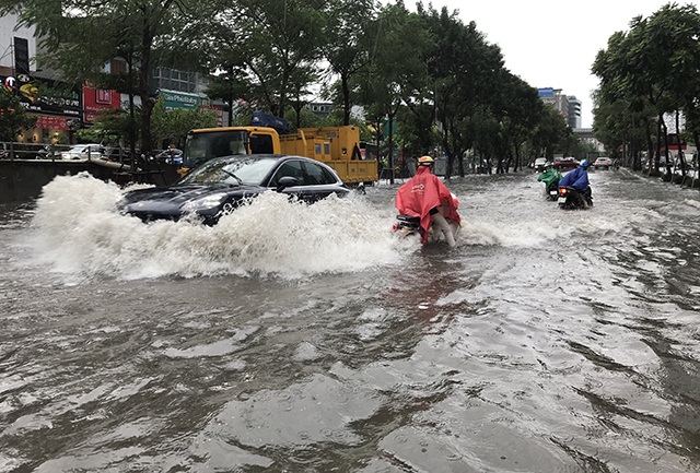 Đường phố Hà Nội thành sông, người dân “be bờ” ngăn nước vào nhà - 1 Đường phố Hà Nội thành sông, người dân “be bờ” ngăn nước vào nhà - 1