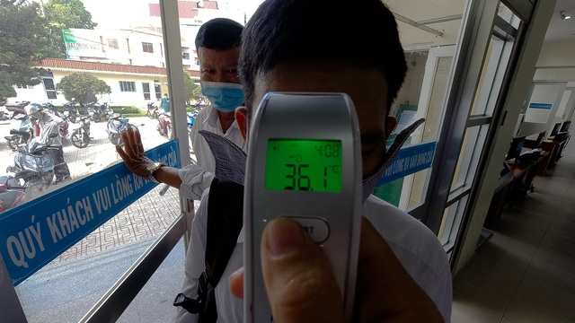 UBND quận đo thân nhiệt, phát khẩu trang cho từng người dân - 2