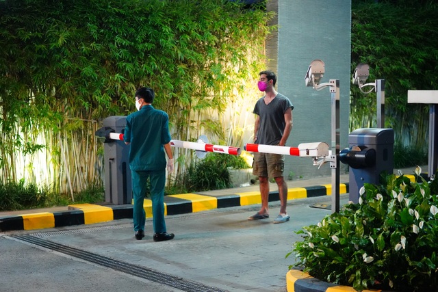 Một cư dân xin bước qua cửa hàng tiện ích bên cạnh mua đồ nhưng lực lượng dân phòng không đồng ý