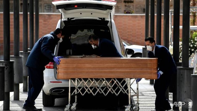mortuaryemployeeswearingfacemaskswheelacoffinintothecrematoriumoflaalmudenacemeteryinmadridduringthefuneralofacovid-19-coronavirusvictim-15850719465205-1585282139455.jpg