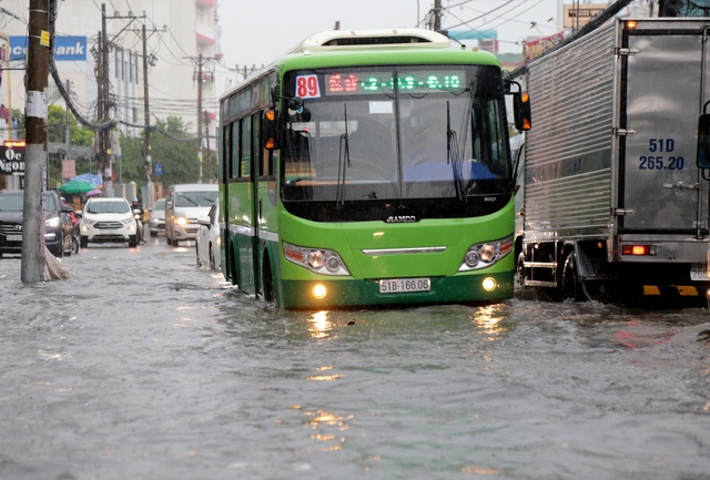 Sài Gòn mưa lớn, đường ngập lút bánh xe, dân vất vả ngăn nước vào nhà - 1