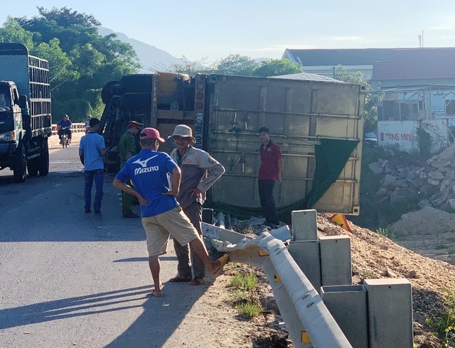 Xe đầu kéo lật nghiêng, thùng container nằm chênh vênh trên thành cầu - 2