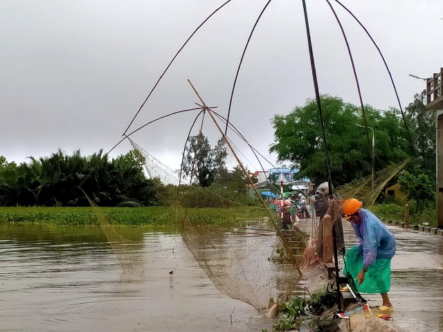 Người dân đổ ra đường giăng lưới bắt cá giữa lũ lớn - 7 Người dân đổ ra đường giăng lưới bắt cá giữa lũ lớn - 7