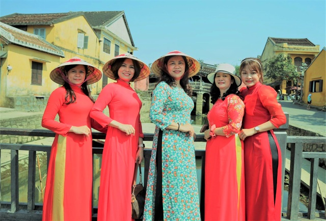 Tourists wear ao dai to check-in in Hoi An ancient town - 1