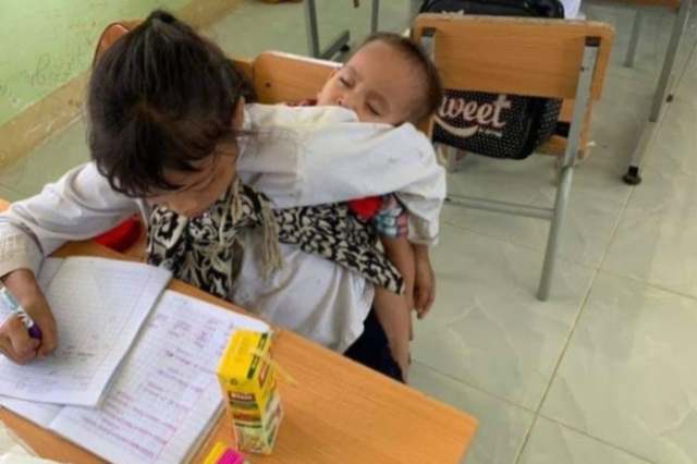 Mẹ lên rẫy, bé gái lớp 3 địu em đến lớp, vừa học, vừa dỗ em ngủ - 1 Mẹ lên rẫy, bé gái lớp 3 địu em đến lớp, vừa học, vừa dỗ em ngủ - 1