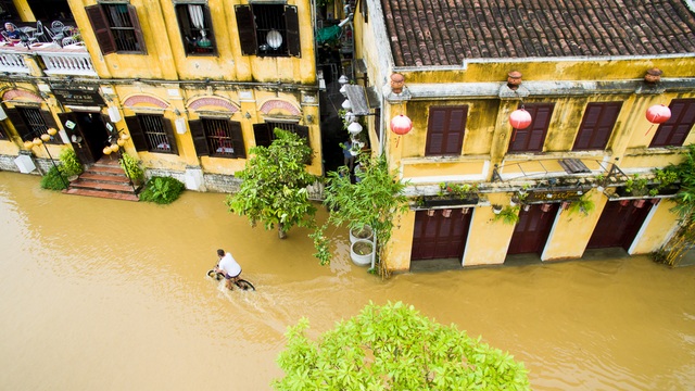 Khách Tây lội nước khám phá phố cổ Hội An... trong lũ - 2 Một du khách nước ngoài đạp xe trên đường Bạch Đằng khám phá lụt Hội An