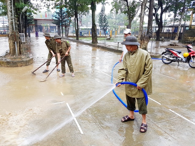 Dân quân, công an đội mưa cùng giáo viên giúp trường dọn lụt - 2 Lực lượng Công an xã Đại An giúp trường dọn bùn non trong sân trường