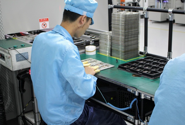 Tìm hiểu quy trình sản xuất smartphone nghiêm ngặt tại nhà máy của Oppo - 5 Một công nhân đang tiến hành lắp ráp chi tiết nhỏ vào smartphone