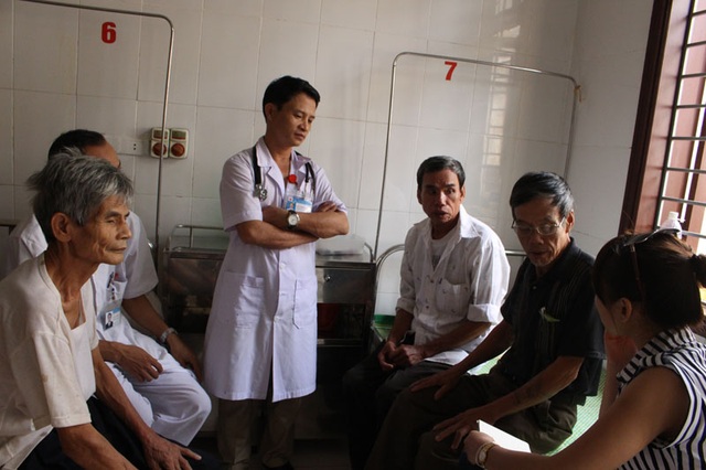 Bác sĩ Hoàng (ở giữa) tới thăm hỏi các bệnh nhân bị mắc lũ còn ở lại điều trị.