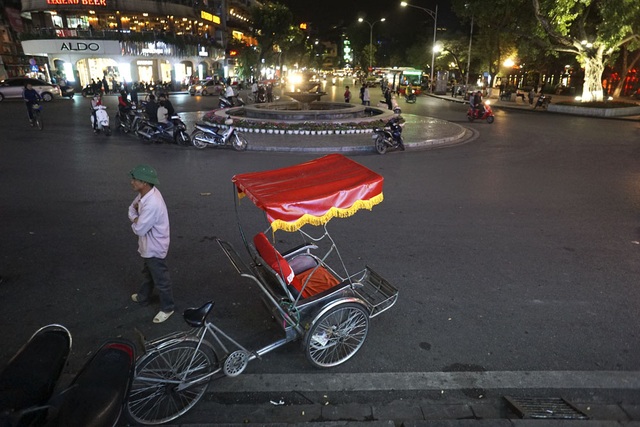 Hà Nội trong đêm gió lạnh tràn về - 6
Người đạp xích lô phong phanh áo mỏng đứng co ro chờ khách bên hồ Gươm.
