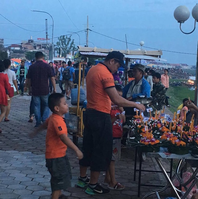 Lễ hội đua thuyền trên dòng sông Mê Kông - 11 Du khách mua hoa để thả trong đêm hội ở sông Mê Kông.
