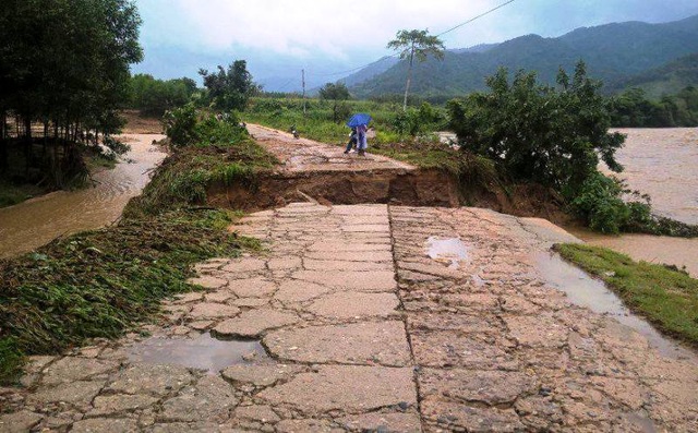 Đón em, học sinh lớp 2 bị nước cuốn trôi - 1 Lũ xé đường lên các thôn ở xã Vinh Kim (huyện Vĩnh Thanh) nhưng giáo viên vẫn lội suối đến trường