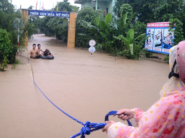 Thắt tim cảnh 4 cô giáo và 15 trẻ nhỏ bu bám một cửa sổ khi lũ ập tới - 1 Thanh niên dùng phao cứu các cháu học sinh trường Mầm non Mỹ Phú 2 (huyện Tuy An, Phú Yên)