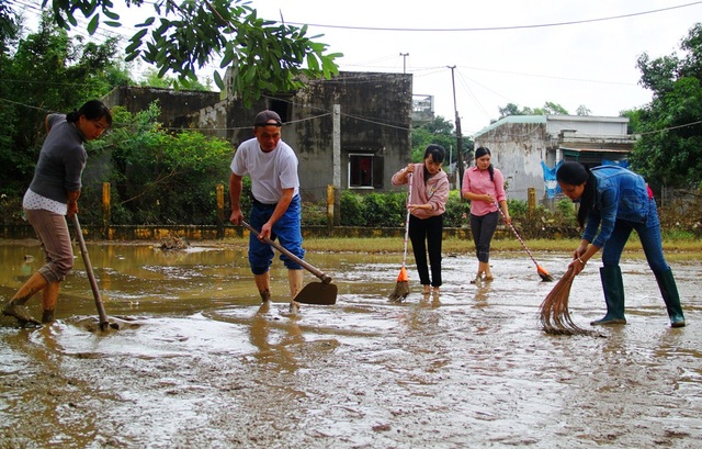 Thầy cô giáo Trường Tiểu học Phước Lộc 2 (huyện Tuy Phước) đang khẩn trương dọn bùn non tràn vào trường do lũ