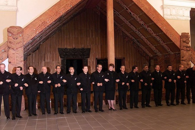 Lãnh đạo 21 quốc gia thành viên của APEC trong trang phục áo khoác đen chụp ảnh chung trước tòa nhà Maori ở New Zealand tại hội nghị năm 1999. (Ảnh: Getty)