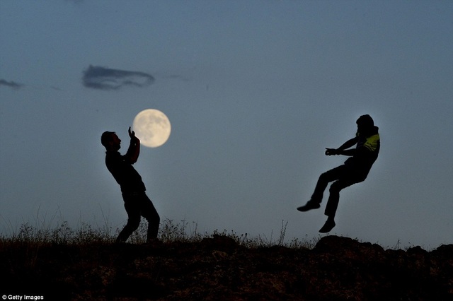 Hai thanh niên cùng tạo thành một bức ảnh siêu thực, khi mặt trăng bỗng hóa thành trái bóng. Ảnh chụp ở Istanbul, Thổ Nhĩ Kỳ.