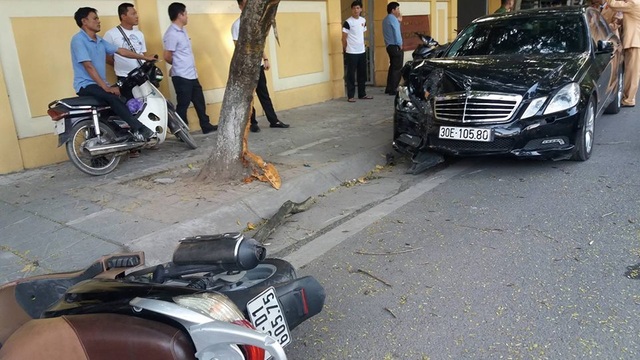 Xe Mercedes húc bay 2 xe máy rồi "phanh" bằng gốc cây - 1 Hiện trường vụ tai nạn.