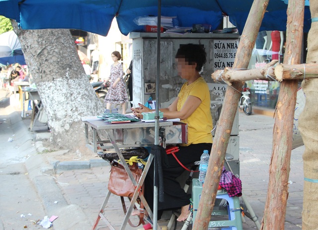 Nguy hiểm rình rập từ những bốt điện trên phố Hà Nội - 3
Người phụ nữ bán vé số ngồi rất sát 1 bốt điện trên phố Huế.