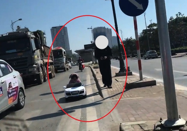 Cháu bé ngồi trong ô tô đồ chơi chạy trên đường phố Hà Nội - 1
Hình ảnh cháu bé ngồi trong ô tô đồ chơi chạy trên đường ngay gần những chiếc ô tô tải khiến người xem... thót tim (Ảnh cắt từ clip).